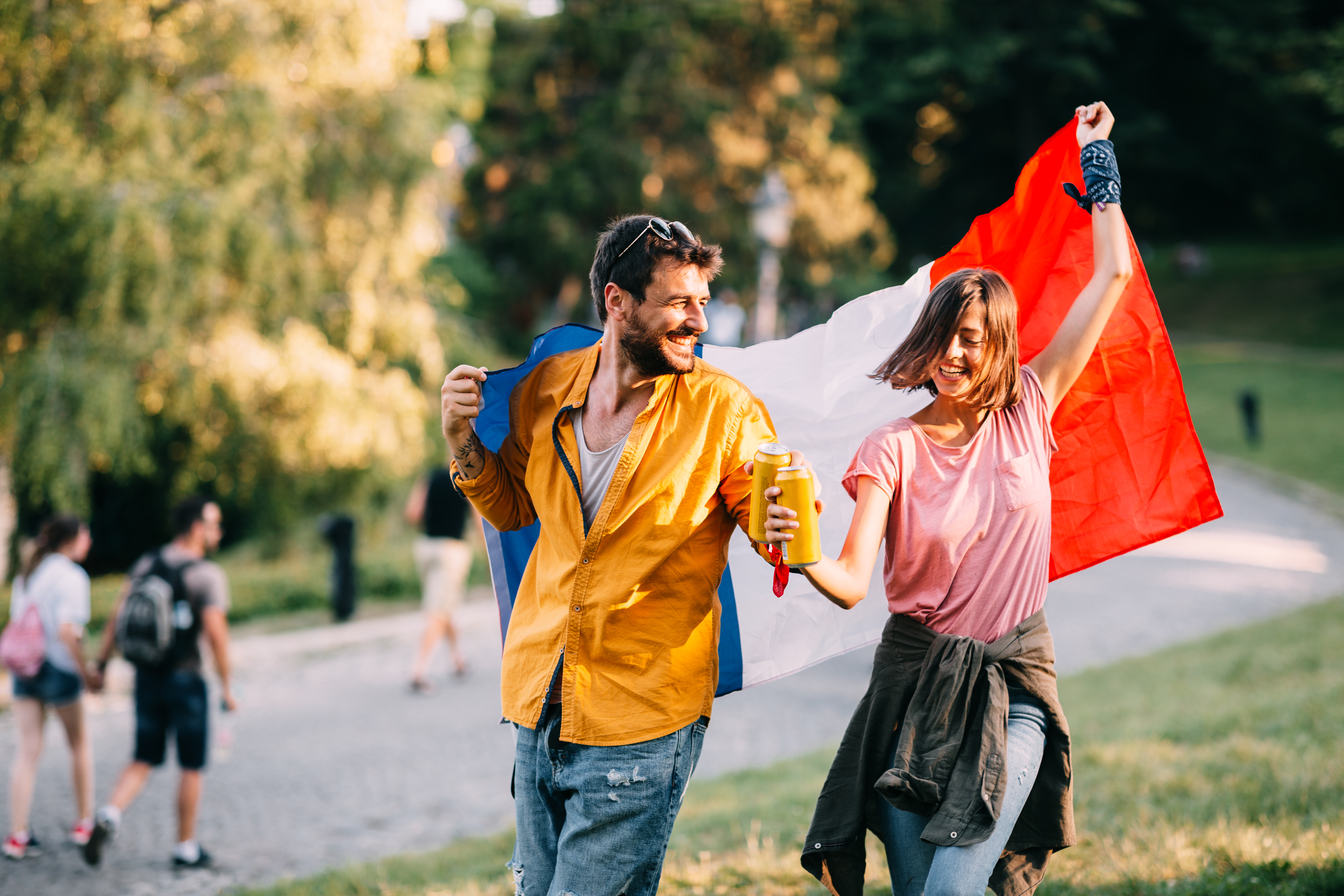 Пара танцует в парке с французским флагом